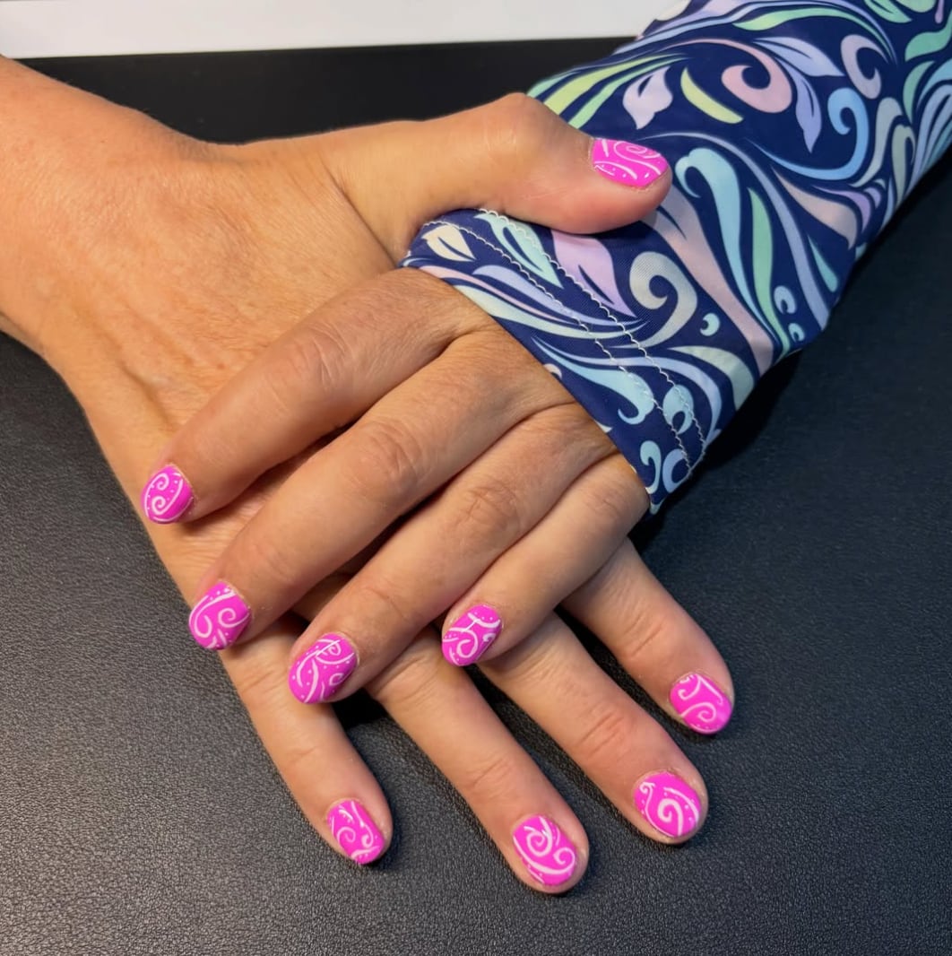 Pink gel manicure with white swirl art