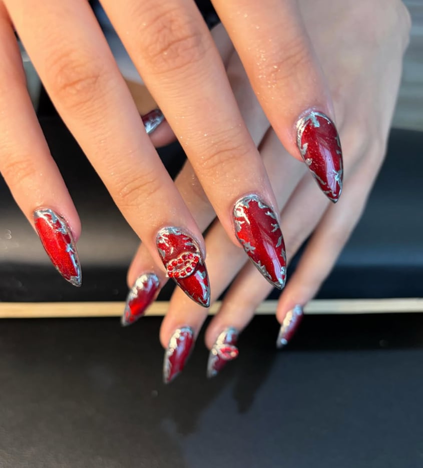 Red stiletto nails with silver chrome and rhinestone heart